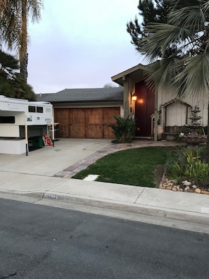Front, Camper will be gone, 2 driveway spaces and 1 garage space.
