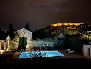 Garden lighting and infinity pool surrounded by 14th century walls