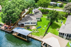 Backyard now includes a fire pit & chairs, & a concrete lounge area w/seats.
