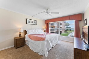 Master bedroom features a king-sized bed with high quality linens and large windows allow plenty of natural li.