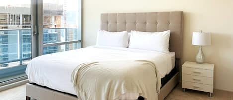 A comfy bed awaits you with a city skyline view