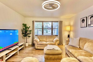 Bright living room with plush seating, wood floors, and modern lighting.