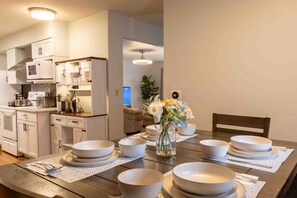 Elegant dining setup with floral centerpiece and view into cozy kitchen