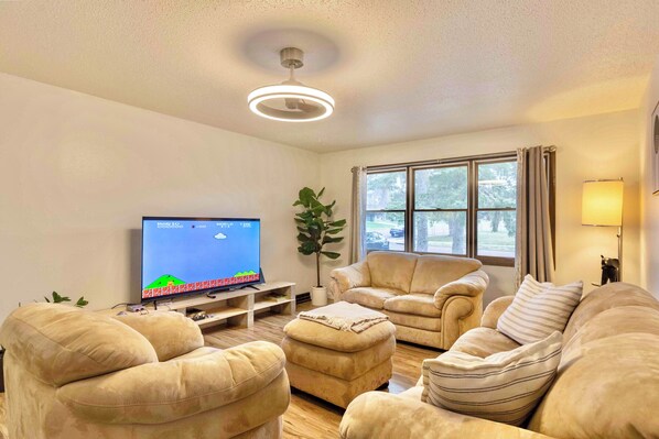 Cozy living room with plush seating and a retro video game on 65” TV