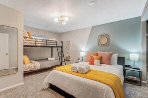 This is one of the bedrooms downstairs with a queen bed and a bunk bed, tastefully decorated and fun!