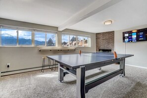 Down below the main floor is the recreation room which has its own bartop seating, arcade machine, and table tennis!
