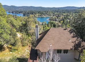 Drone view of cabin with lake behind.