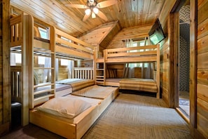 This rustic haven features a clever use of space with bunk beds, providing not only a warm and inviting atmosphere but also the perfect setting for shared adventures.