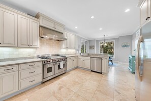 The fully stocked gourmet kitchen. Travertine floors and subway tiled walls