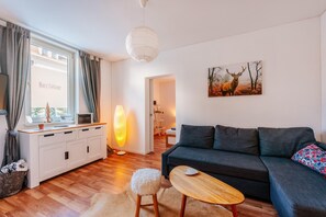 Wohnzimmer mit Schlafcouch und Durchgang zum Schlafzimmer