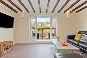 Forge Bridge sitting room with patio doors to riverside decking and mountain view