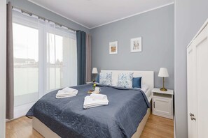 A bedroom featuring a large double bed dressed in fresh white linens. A pair of bedside tables with lamps adds functionality and charm.