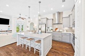 A fully equipped kitchen with stylish white cabinetry, a spacious island, and pendant lighting for a seamless cooking experience.