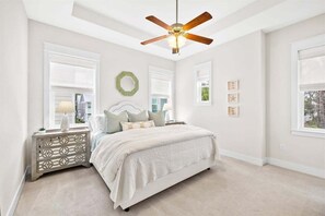 A serene master bedroom featuring a cozy king-sized bed, soft lighting, and large windows for natural sunlight.
