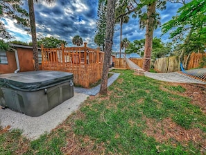 Backyard with hot tub and hammocks.