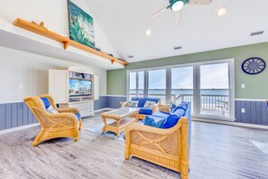 The cathedral-ceilinged great room includes unparalleled ocean views, large screen TV, and comfortable furnishings for a serene space to settle for the evening.