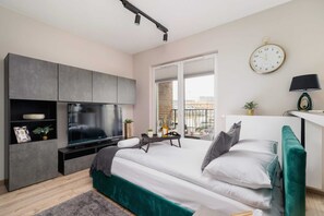 The same bedroom from a different angle, showing a small desk and a view outside the window. The green theme is consistent, adding a fresh touch to the room.