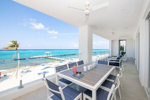 Large private balcony with patio loungers and an al fresco dining table for seaside meals.