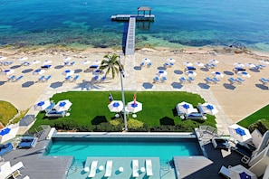 View of the resort's oceanfront pool deck. The resort's dock is equipped with a ladder for gentle water entry and a cabana for shade.