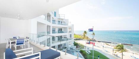 Private ocean balcony with alfresco dining table and loungers. 