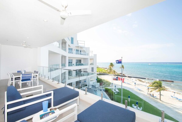 Private ocean balcony with alfresco dining table and loungers. 