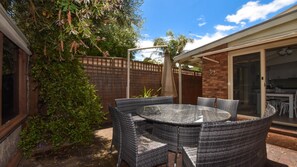 Alfresco Dining  with table for 8 with large sun umbrella.