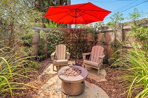 Soak up the sun by day and unwind under the stars by the fire pit in this charming backyard escape.