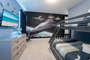 Blast off into adventure in this space-themed room with cozy bunk beds and galactic decor, perfect for young explorers!