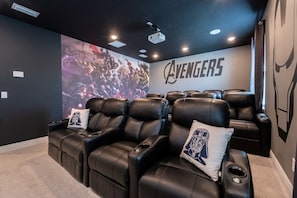 Experience movie magic in this Avengers-themed home theater with plush recliners and a state-of-the-art projector.