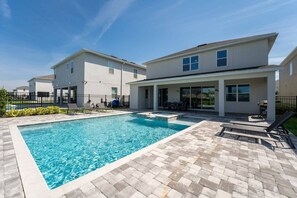 Relax by your private pool oasis with ample lounging space and a covered patio for perfect outdoor gatherings.