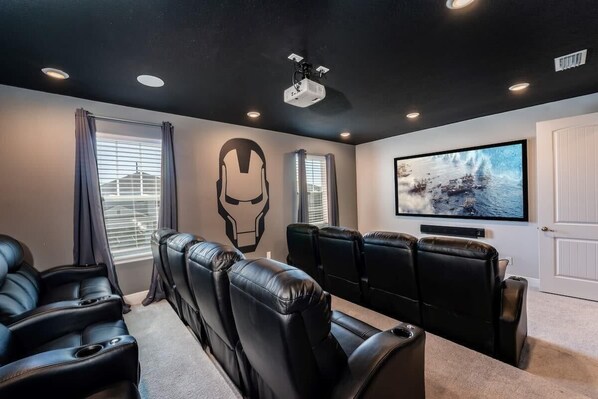 Experience cinematic thrills in this superhero-themed home theater with plush recliners and immersive sound.
