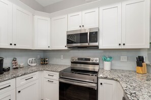 Kitchen with SS microwave, dishwasher, stove, and door ice & water dispenser.