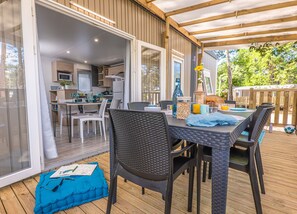 Covered outdoor dining space with cozy seating, perfect for enjoying meals in fresh air.