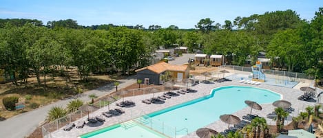 Large swimming pool area with ample seating and sun umbrellas, creating a resort-like ambiance.