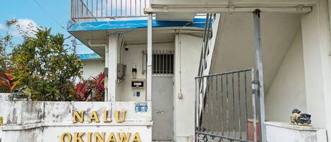 ・[Exterior] The yellow sign of nalu.okinawa and the Shisa on both sides are landmarks.