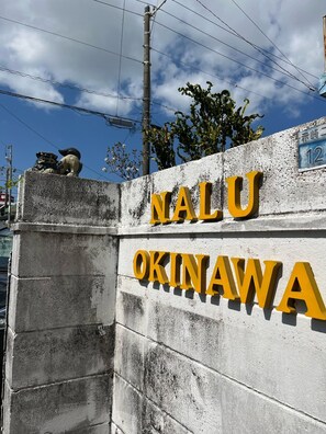 A yellow signboard and Shisa are landmarks