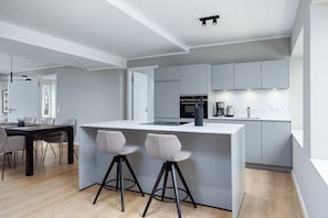 Wohn-Essbereich mit Esstisch, Sitzgelegenheit und Küchenzeile
