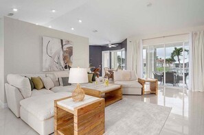 LIving Room with Airy Coastal Furniture and Beautiful View to Pool Area