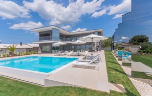 The exterior of the luxury villa Nimai Luce in Istria with an outdoor swimming pool and landscaped lawn in Kaštelir in Istria