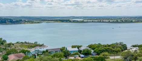 Drone shot above the property of Canyon Lake. Shows the type of vast 180 degree view you have from the upstairs covered patio (perfectly framing the sunset) and close access to the water!