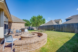 (Prior to new outdoor couches and TV being installed on back patio) Large backyard, with wood firepit, gas Blackstone flattop griddle grill, picnic table and shaded dining area.