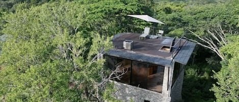 Aerial shot of the tower with the ocean in the background, main house on left