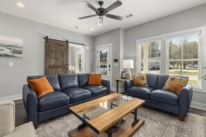 Bright, spacious living room, barn door leads to dedicated workspace.