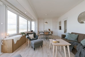 Spacious living area with dining table, surrounded by seaviews