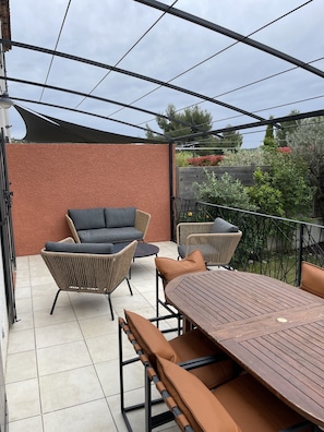 Terrasse avec salon de jardin cosy et table à manger en extérieur 
