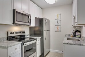 Chefs kitchen , fully stocked with cookware, plates and utensils.