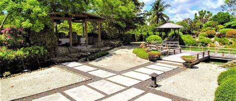 Japanese and Balinese elements with pergolas, lush foliage, and serene gateways.
