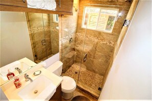 Modern bathroom with clean lines, marble, ambient lighting, and spacious shower.