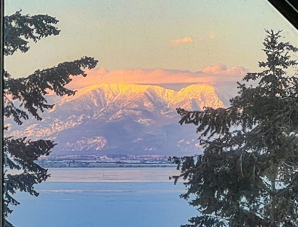 View of Flathead lake and the Swan mountain range. The lights of Big Fork can be seen across the lake at night. So beautiful! 