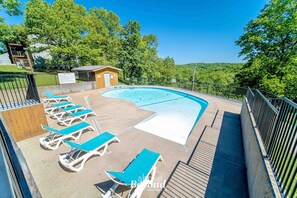 Pool with lounge chairs and scenic surroundings.
